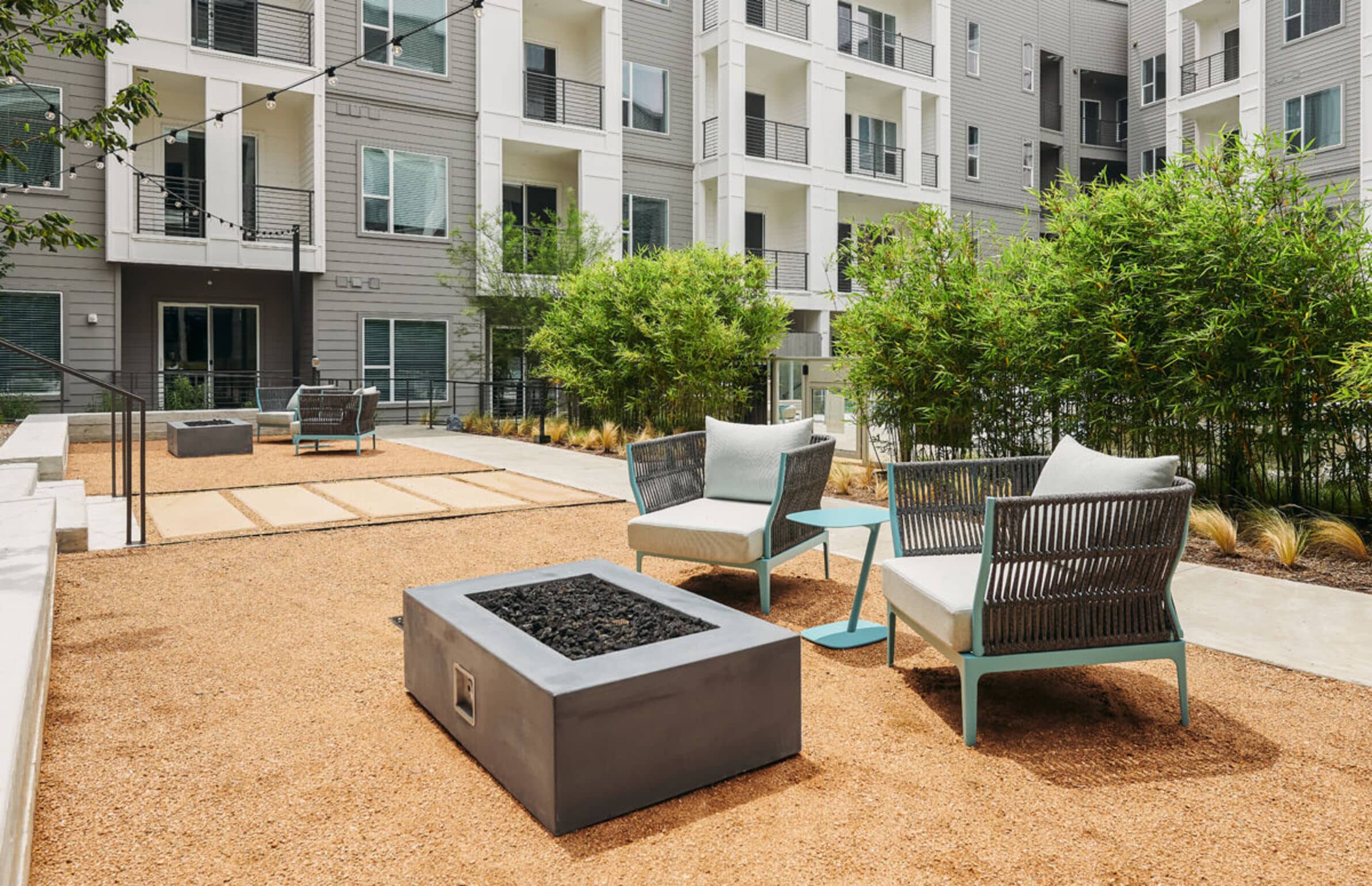 Outdoor patio at The Copeland with two chairs, a fire pit, and a side table.
