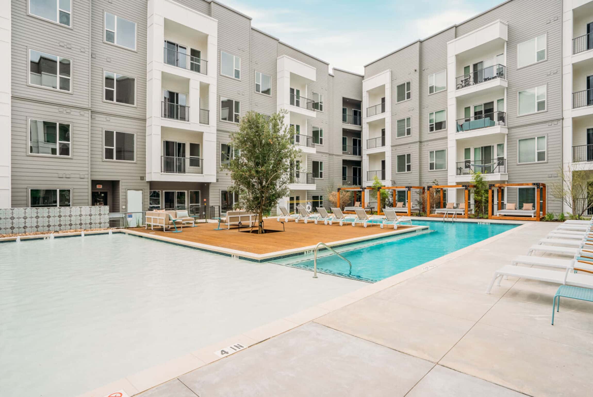 The Copeland complex with a pool, deck, lounge chairs, and cabanas on a sunny day.