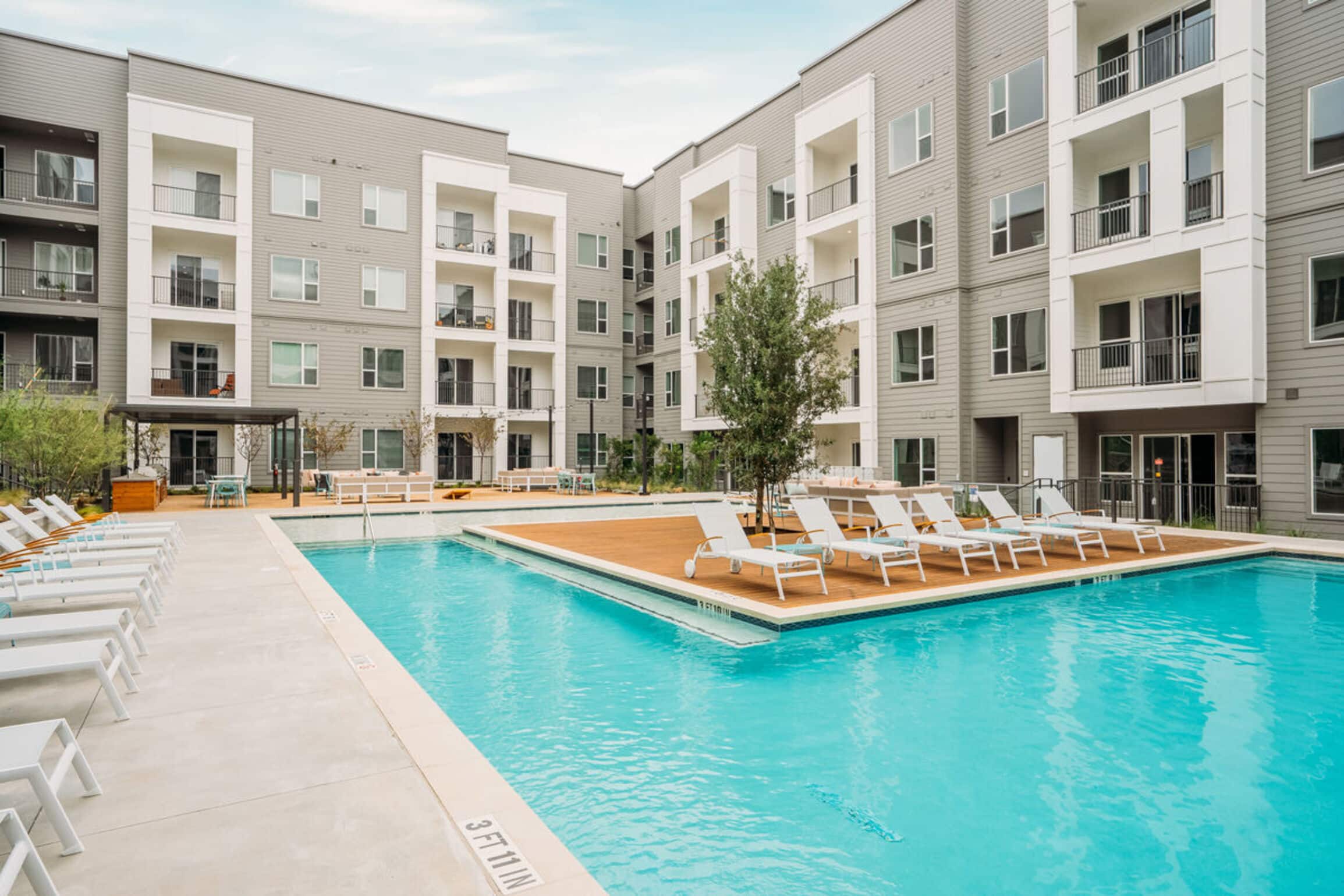 The Copeland complex with balconies overlooking a swimming pool and lounge chairs on a sunny day.