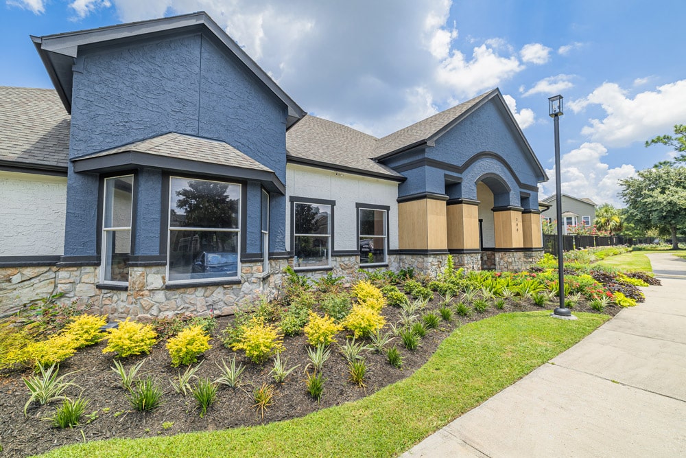 A landscaped yard at The Bryx at Kingwood, and a cloudy sky in the background.